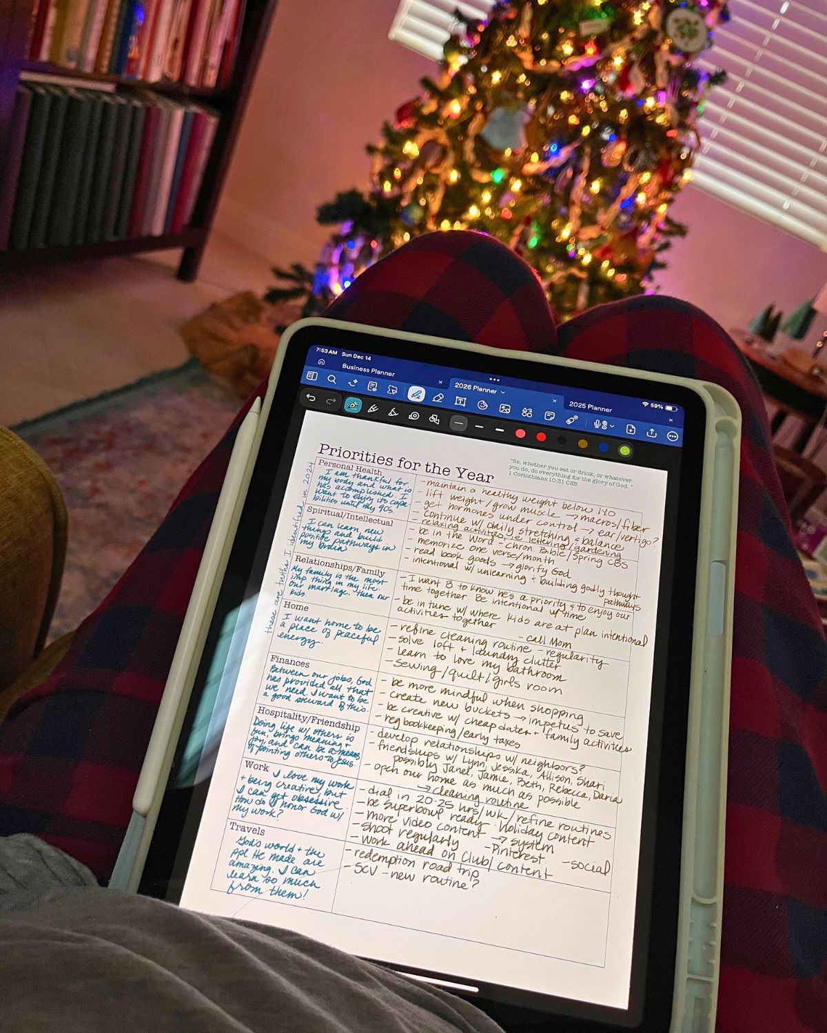 2026 priorities page open on iPad in foreground with lit christmas tree in background.