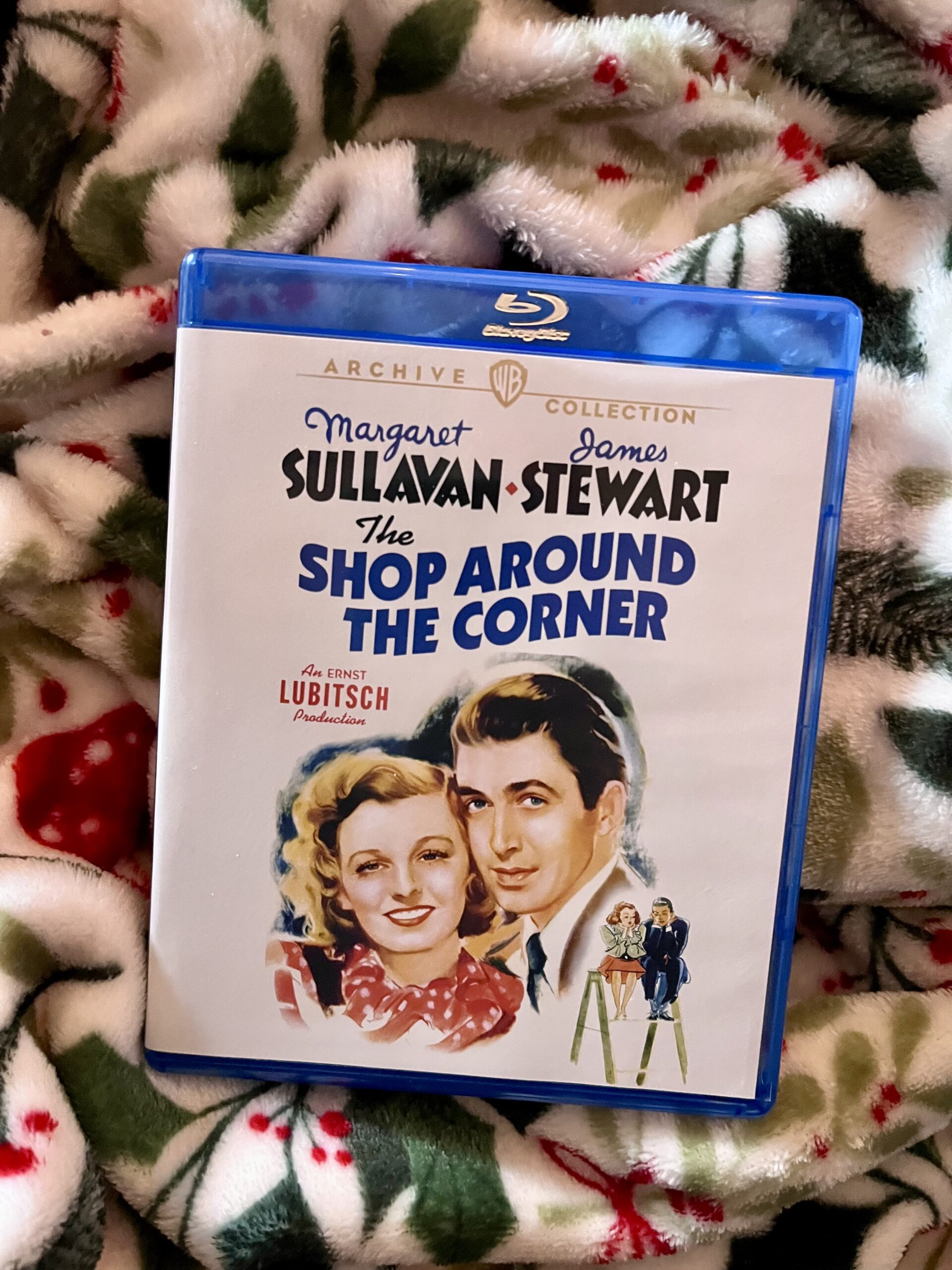Blu-ray case for shop around the corner on Christmas blanket.