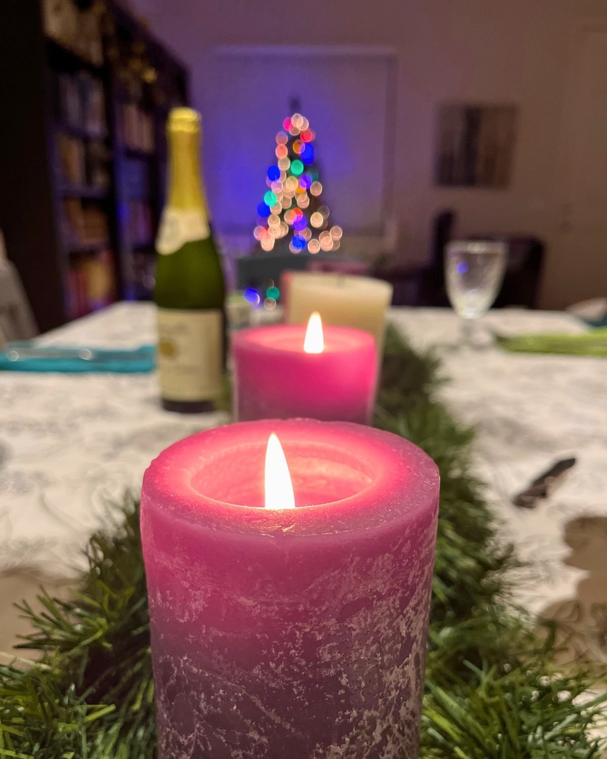 Two advent candles lit on dinner table.