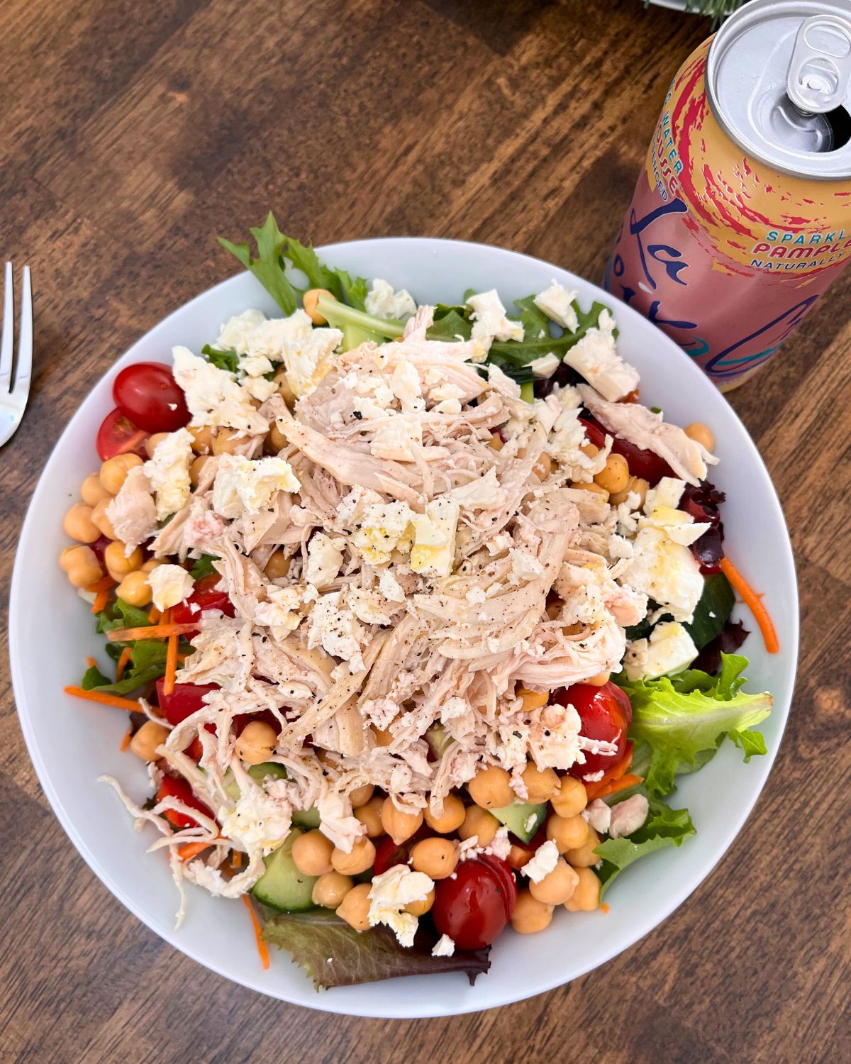 Salad with chicken and feta on table with a la croix can.