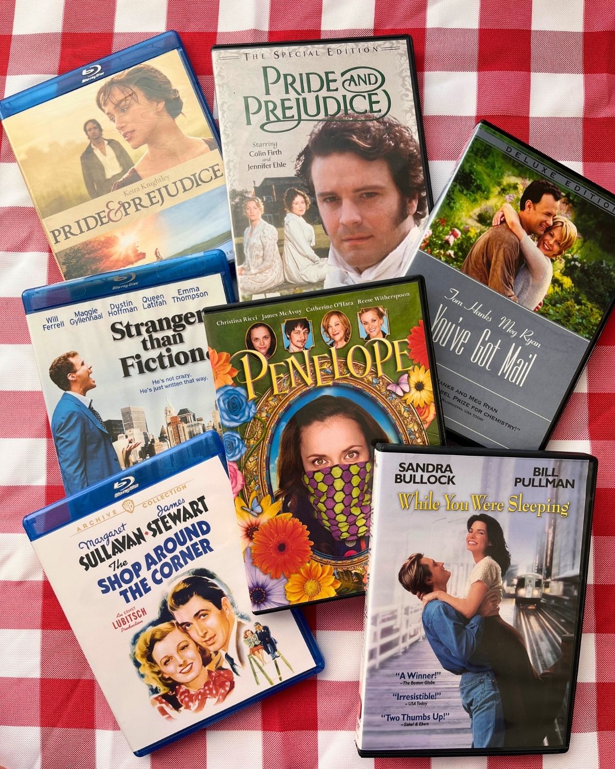 scattering of DVDs and Blu-rays on red-checked table.