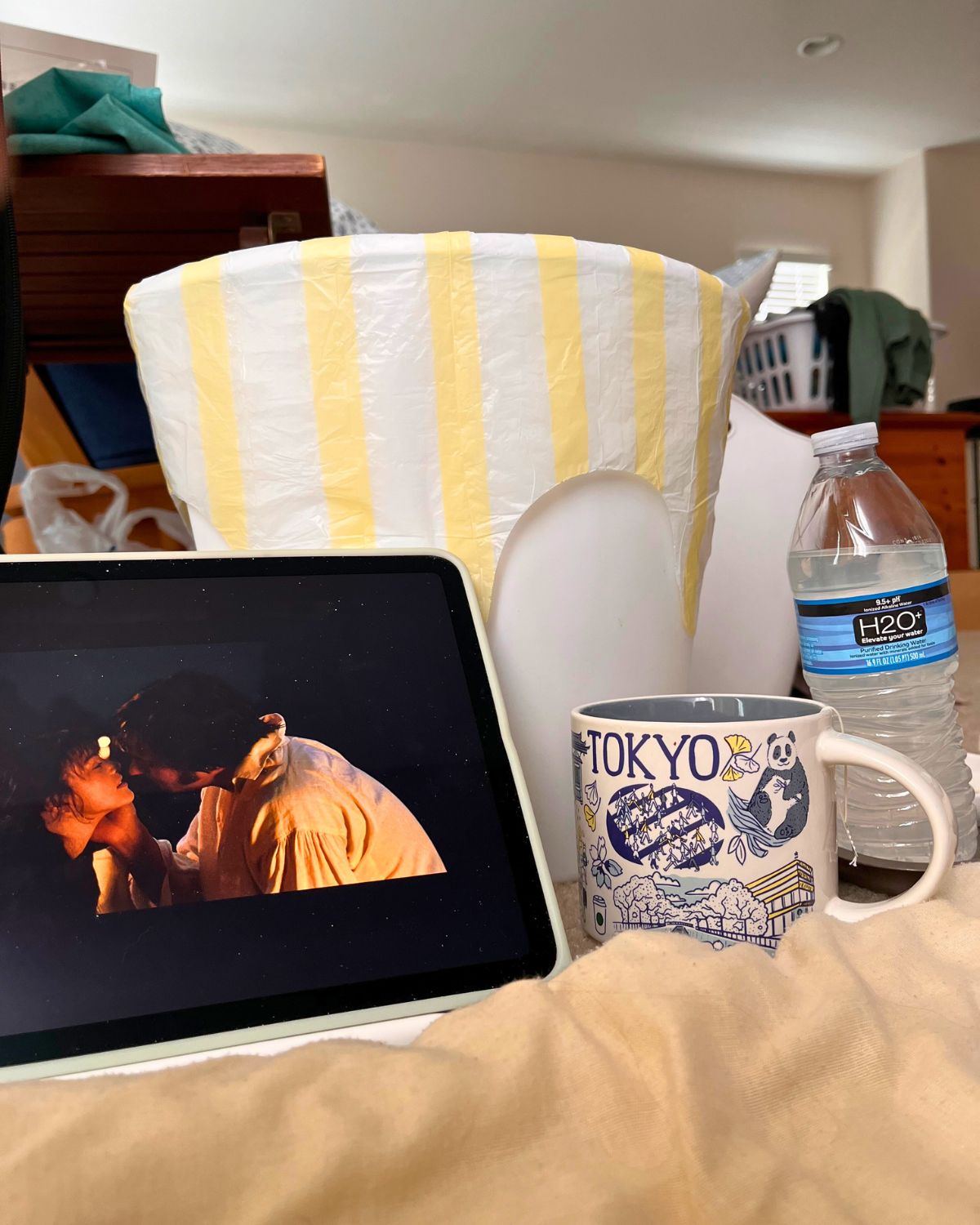 view of iPad, tea, and trashcan from sick bed.