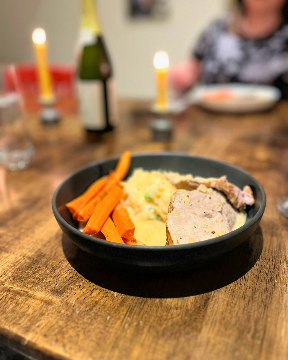 sunday dinner plate with candles lit on the table.