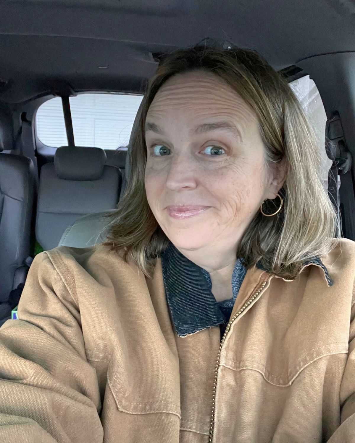 jessica in the car wearing Bryan's Carhart jacket.