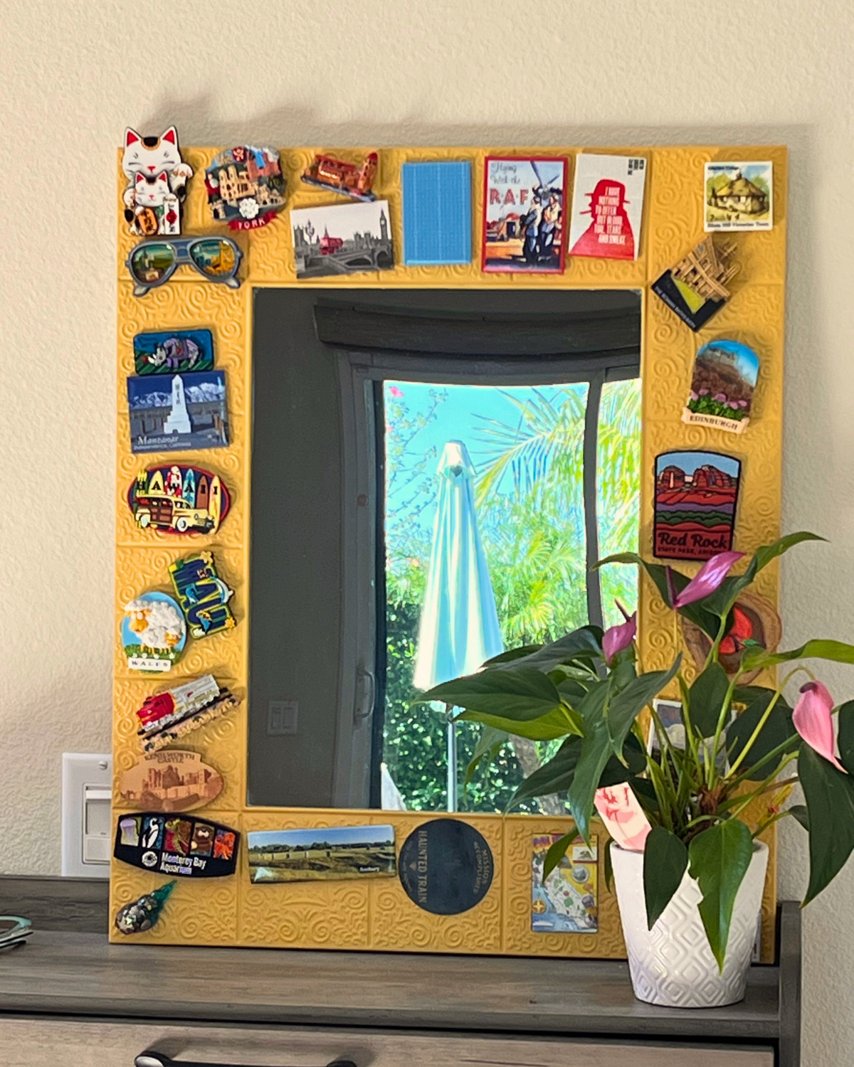 yellow mirror with travel magnets around the edges.