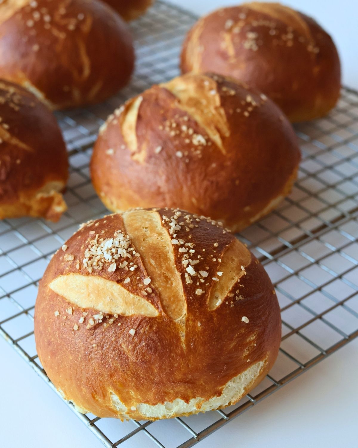 pretzel rolls laid out on a wire rack.