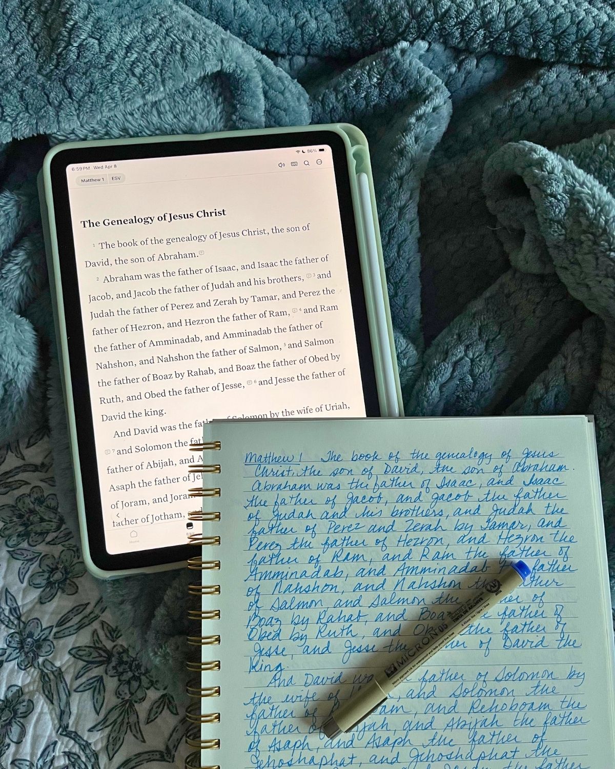 Bible copywork spread on bed with iPad.
