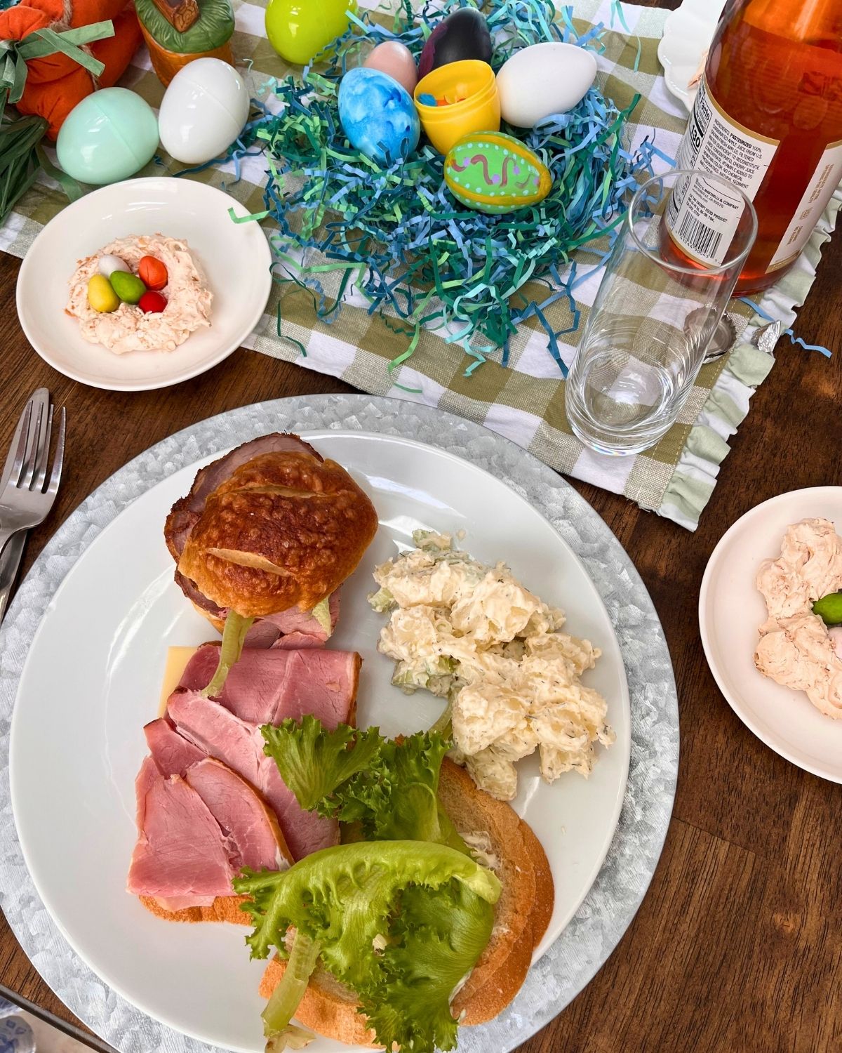 easter table with decor, dinner plate, and macaroon nests.
