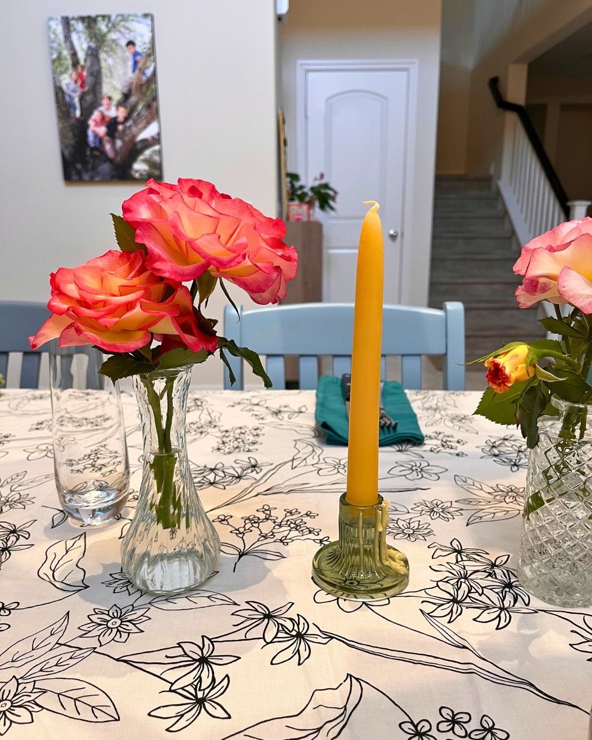 sunday dinner table set with roses from the yard and beeswax candles.
