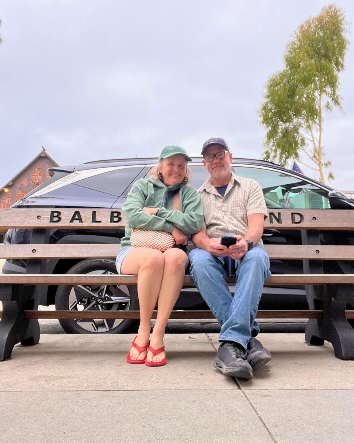 bryan and jessica on bench on balboa island.
