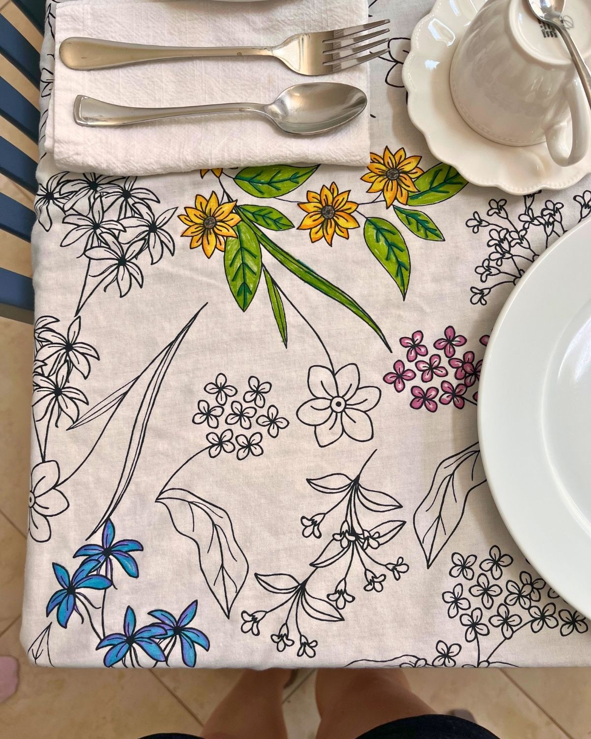 floral tablecloth on table set for tea.
