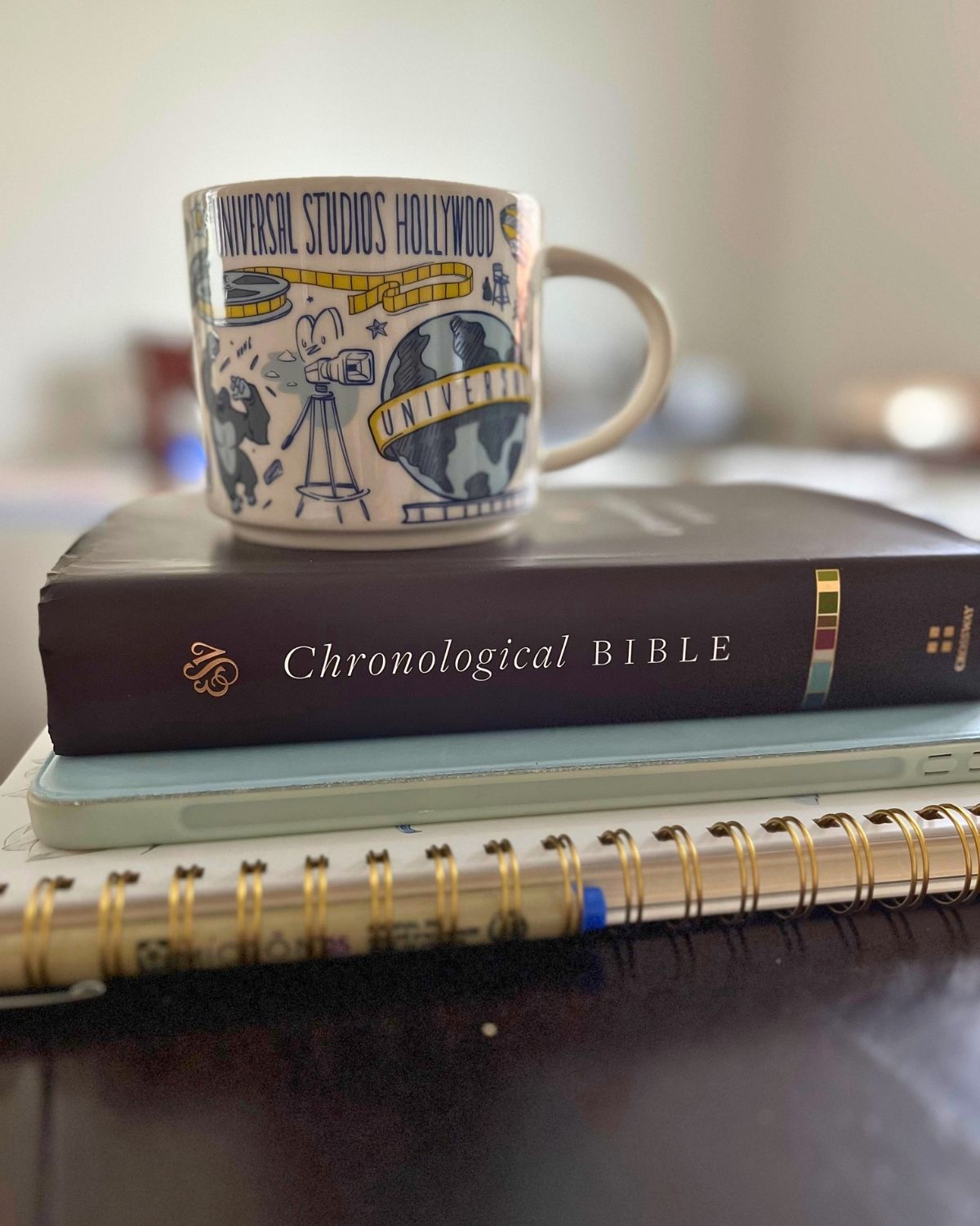 stack of reading and writing materials with a mug on top.