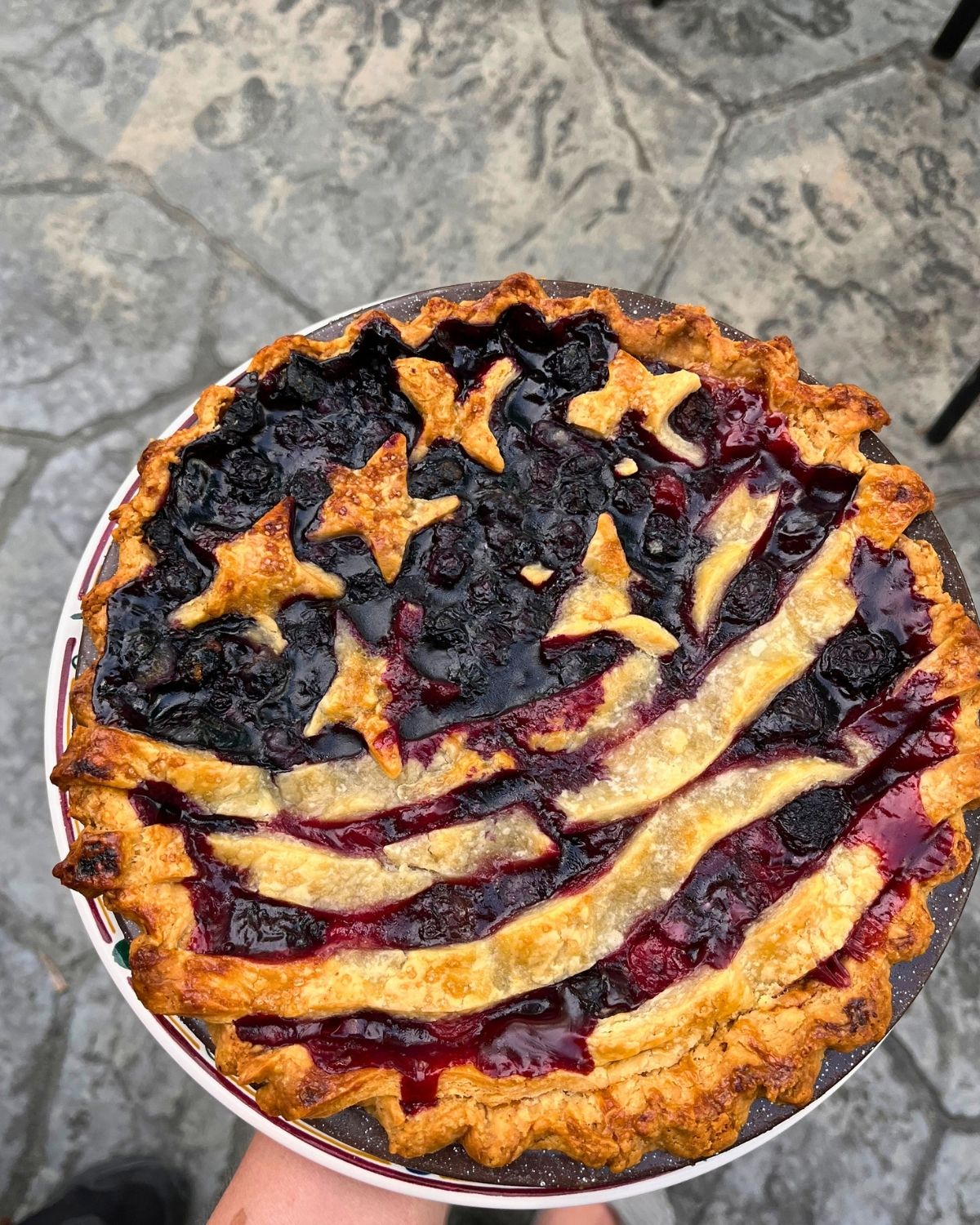 holding a flag pie above a concrete floor background.