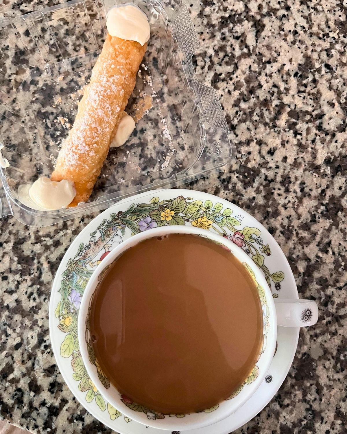 take home back of canolli next to tea cup.