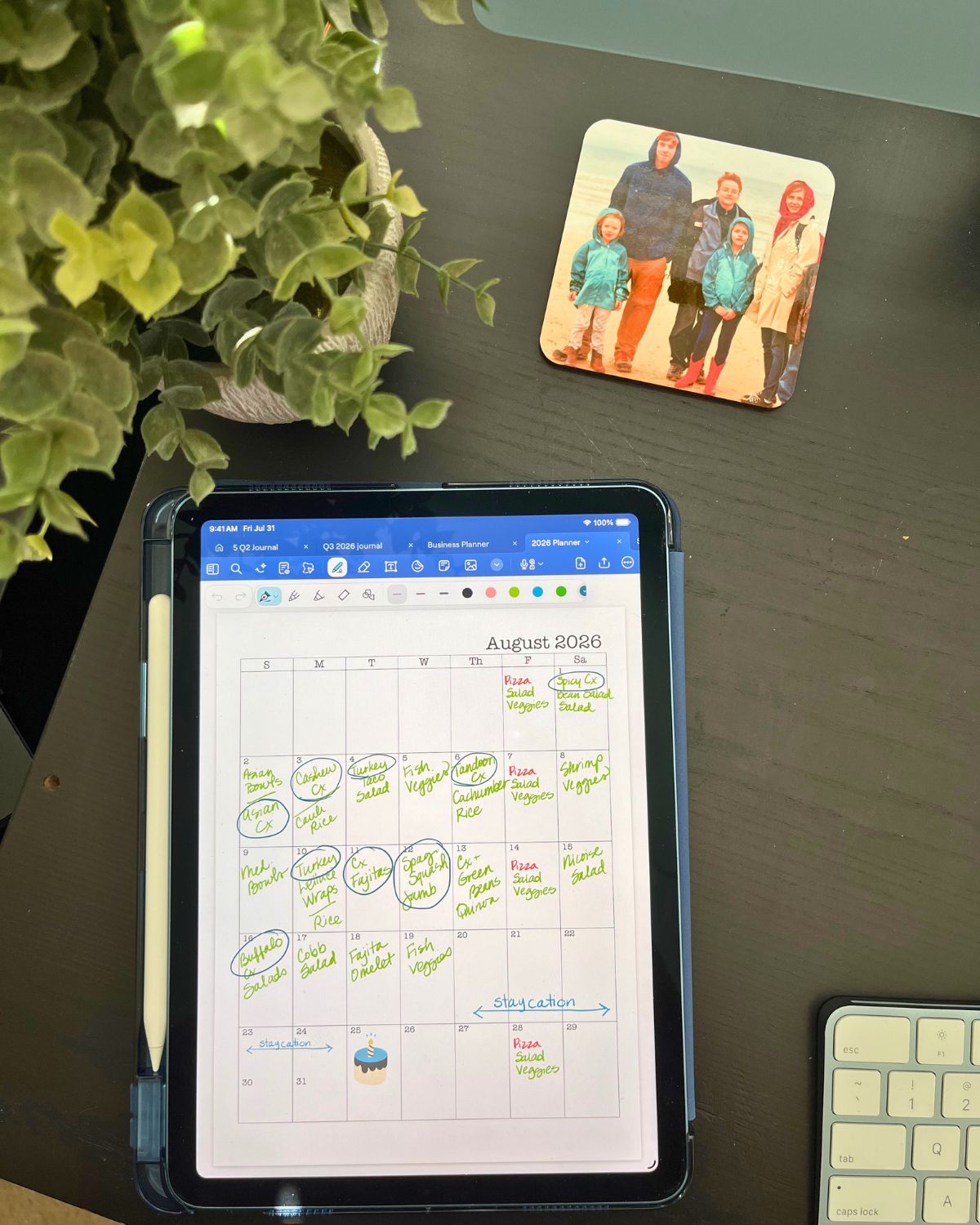 meal plan for august on ipad on table near photo, computer, and potted plant. 