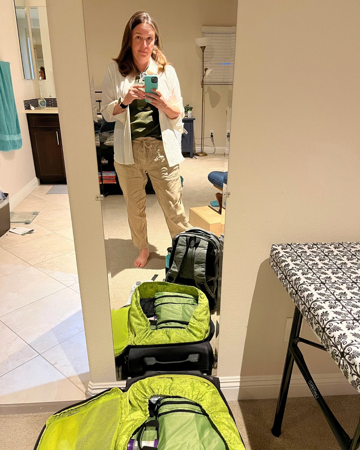 jessica standing packed and ready to go by open suitcase.