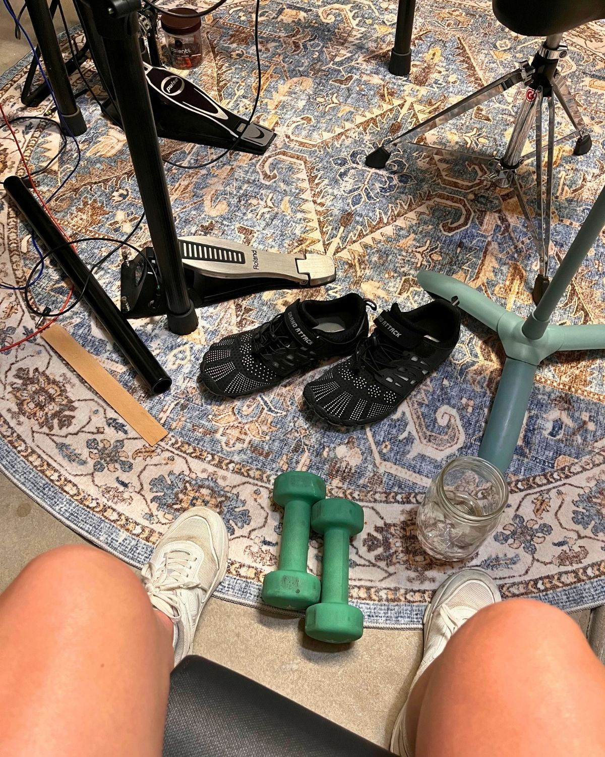 sitting on workout bench with weights on floor near drum kit.