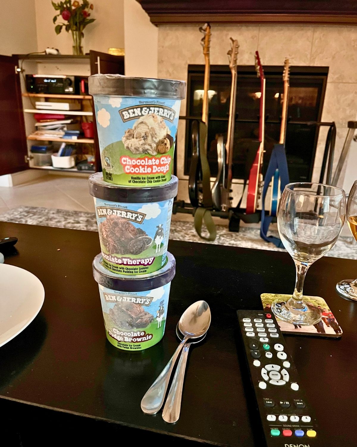 a stack of ben and jerry's on the coffee table near the remote.