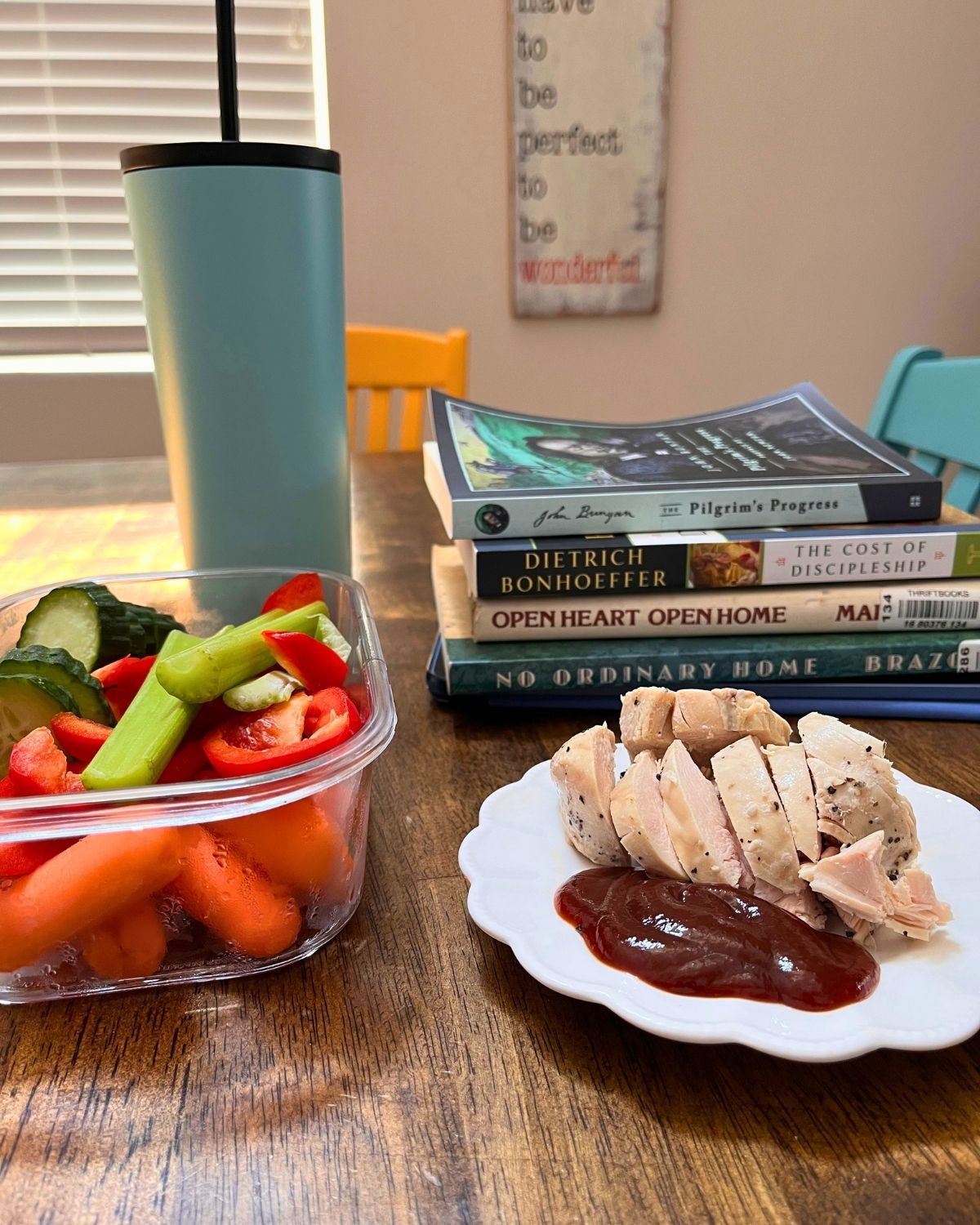 lunch plates, water bottle, and stack of books on table.