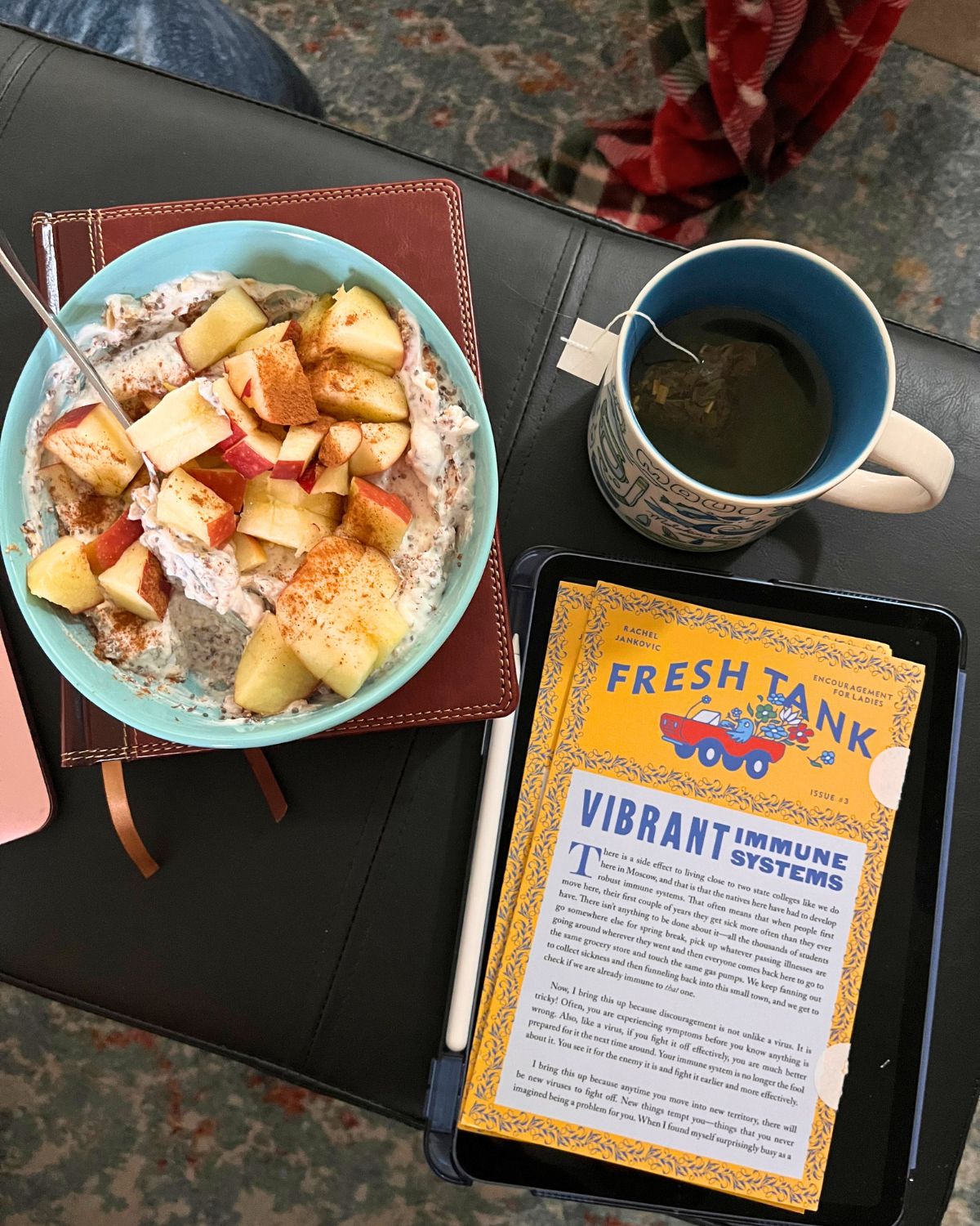 bowl of breakfast on bible with mug of tea and paper copies of fresh tank.