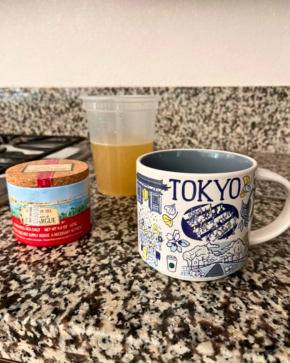 salt cellar next to container of stock and a tokyo mug on kitchen counter.