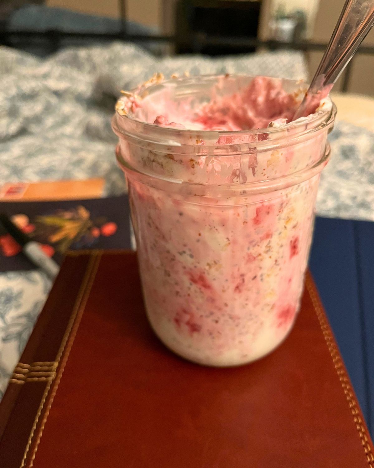 raspberry muesli yogurt in a jar atop the bible on my bed.