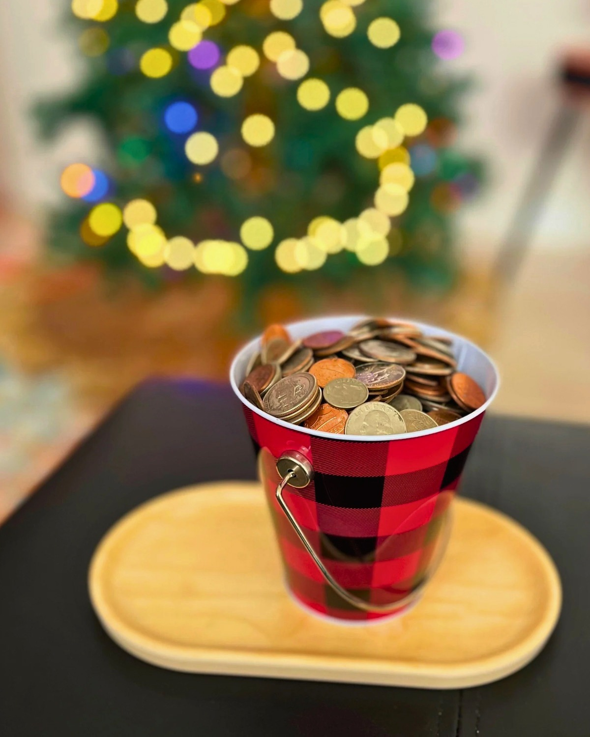 plaid bucket of coins by christmas tree.