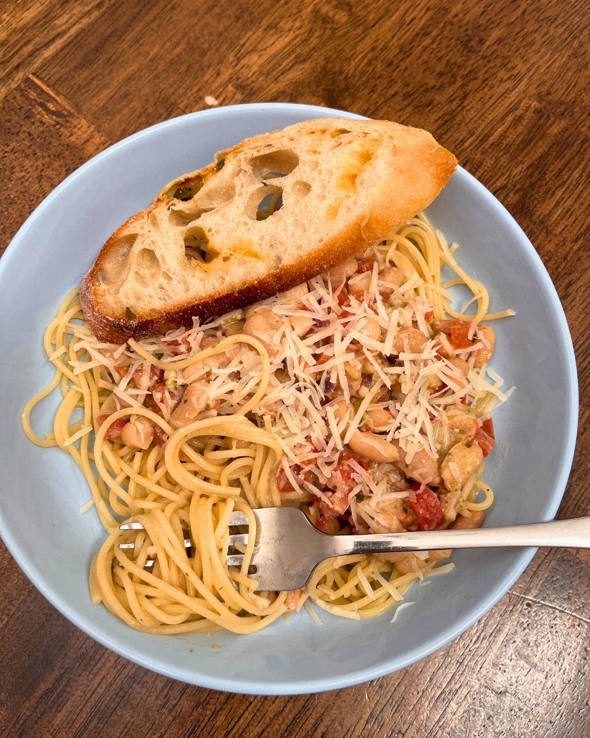 bowl of pesto beans on pasta with jalapeño cheese bread.