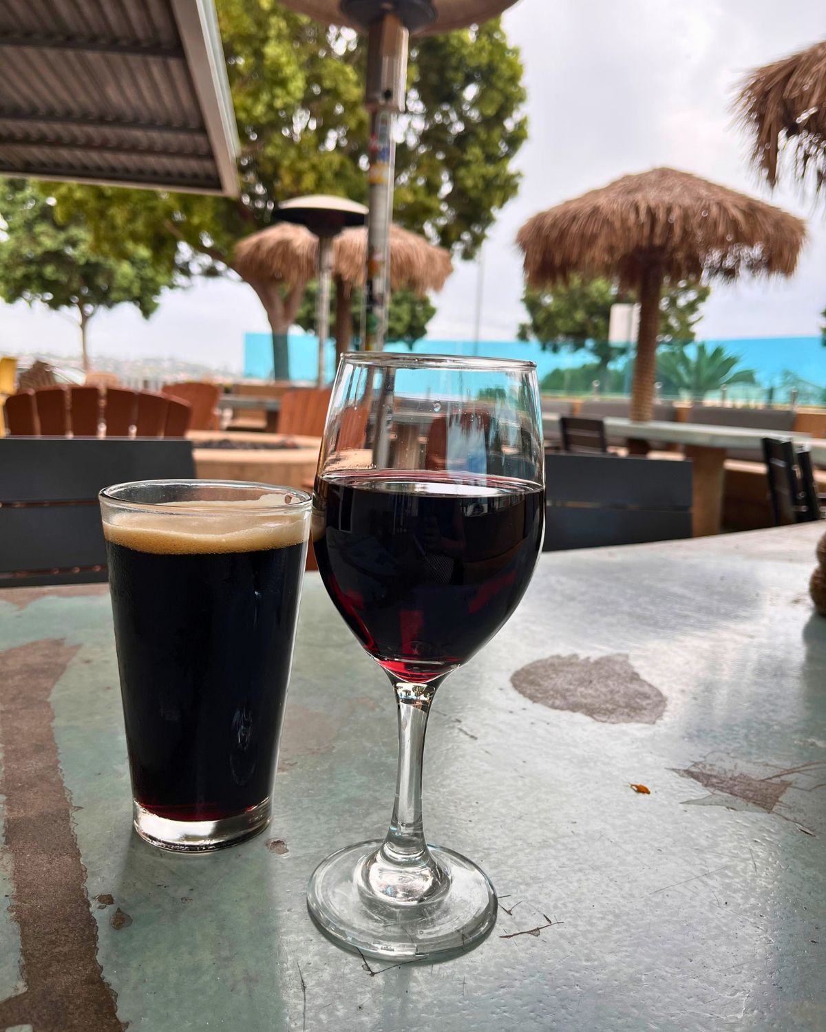 pint of beer and glass of wine on table at restaurant patio.