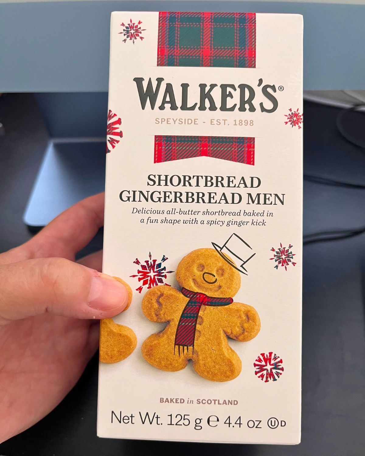hand holding box of walker's gingerbread men.